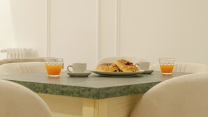 Una escena de desayuno con un plato de pasteles y dos vasos de jugo de naranja sobre una mesa de mármol.