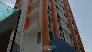 Ένα ψηλό κτίριο με πολλά μπαλκόνια και  μονάδες κλιματισμού.