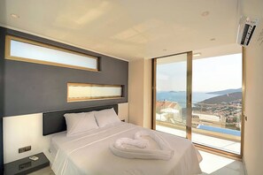 Ein modernes Hotelzimmer mit einem großen Bett, Meerblick und einem Balkon.