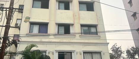 Un hotel su più piani con un cartello pubblicitario che riporta 'Hotel Vaishnavi'.
