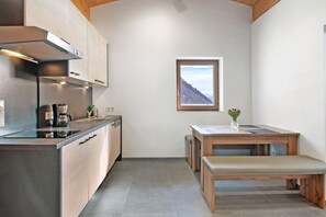 Una cocina moderna con estufa integrada, cafetera y ventana con vista a la montaña.