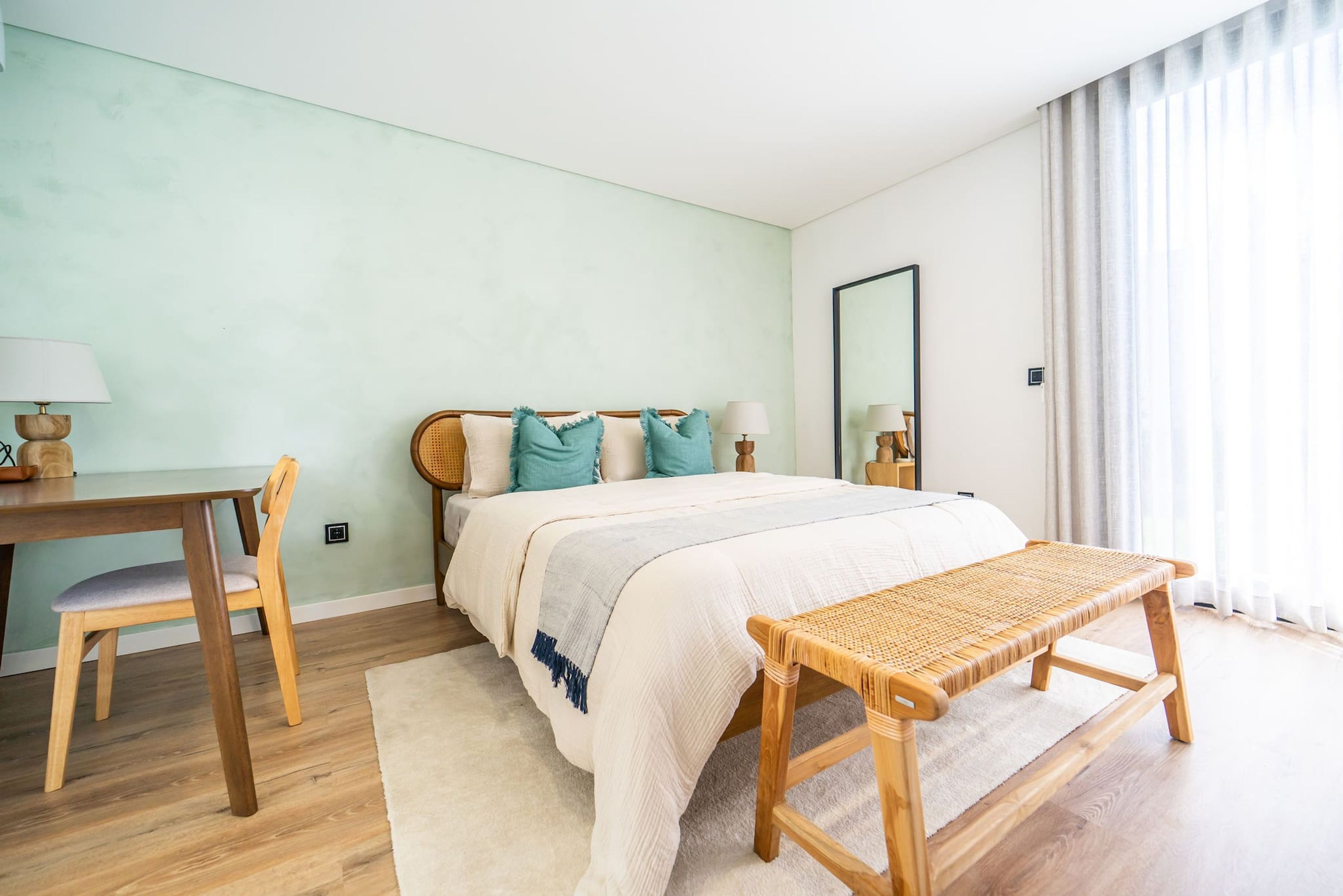 Ein Schlafzimmer mit einem Bett, einem Schreibtisch und einer Bank.