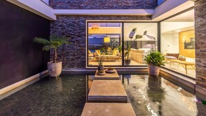 A modern indoor pool area with a glass wall offering a view of a living room. - Setubal Lisbon Dream Getaway Villa do Sol (Seixal)