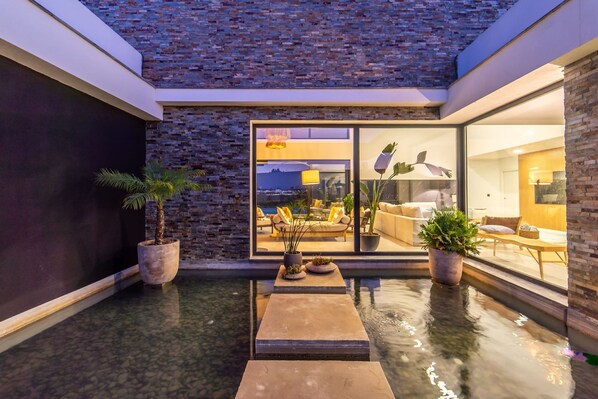 A modern indoor pool area with a glass wall offering a view of a living room. - Setubal Lisbon Dream Getaway Villa do Sol (Seixal)