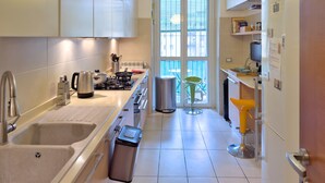 Una cocina moderna con estufa a gas, lavamanos y vista al exterior a través de un ventanal grande.