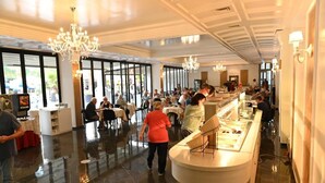 A spacious hotel lobby with a central counter, chandeliers, and large windows. - Hotel Onufri (Golem)