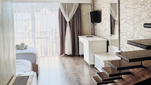 A modern hotel room with a wooden ceiling, a large window with curtains, a bed, a desk, and a mirror. - Hotel Onufri (Golem)