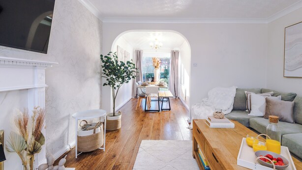 A modern living room with a fireplace, a dining area, and a sofa.