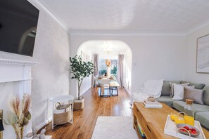 Moderni olohuone, jossa on takka, ruokailutila ja sohva.