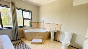 A bathroom with a bathtub, a sink, and a toilet. - Phola la bed and Breakfast (eMthonjaneni)