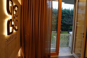 Entrada de un hotel con un muro de madera que muestra el nombre "Hortus Hotel".