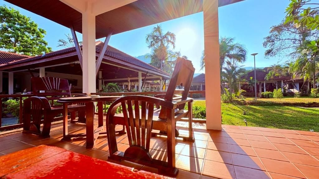 An outdoor seating area with wooden furniture and a covered structure.