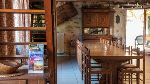 A wooden dining table with chairs, a wooden cabinet, and a radiator in a rustic interior.