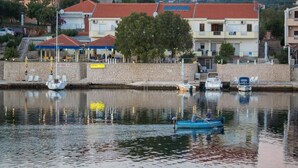 Uma área à beira-mar com edifícios, um restaurante e barcos.