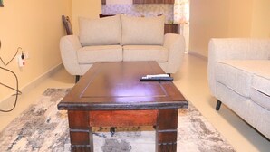 Ein Wohnzimmer mit einer Couch, einem Couchtisch und einem Teppich.