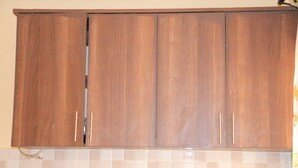Eine Küche mit Holzausstattung und einer gefliesten Spritzschutzwand.