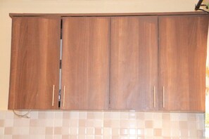 A kitchen with wooden cabinets and a tiled backsplash. - 2-bedroom apartment in excellent Nairobi with fitness room access (Nairobi)