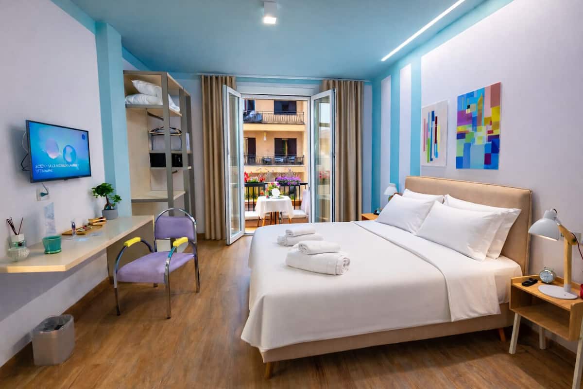 Una habitación de hotel con cama, escritorio, silla y televisor.