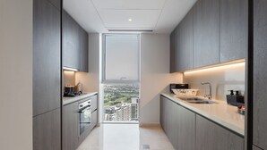 Eine schmale, moderne Küche mit einem großen Fenster und Blick auf die Stadt.