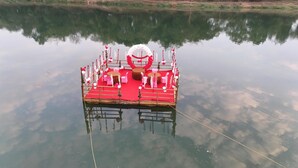 Un bateau à quai, transformé en scène avec des sièges et une corde attachée au quai.