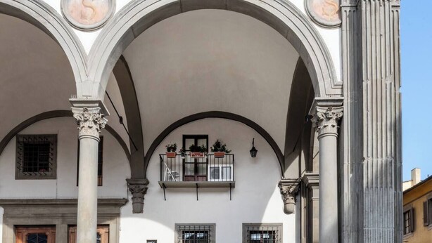 Un edificio de estilo arquitectónico clásico, con ventanas de arco y columnas.