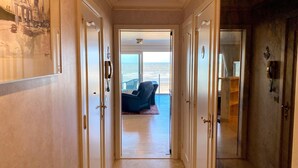 Un pasillo que lleva a un balcón con vista al mar.