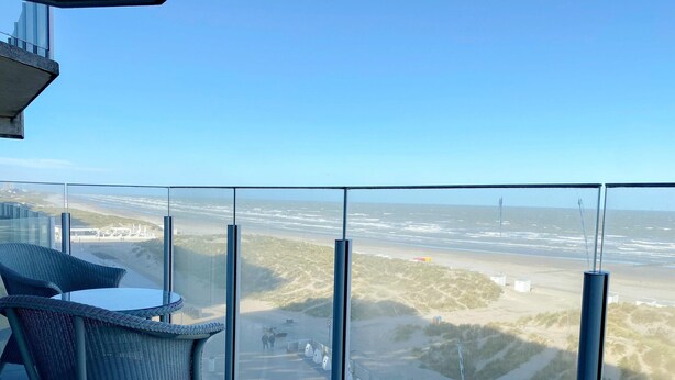 Un balcón con vista a la playa y al océano.