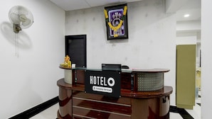 Een hotel receptie met een bord waarop 'HOTELO Company Serviced' staat.