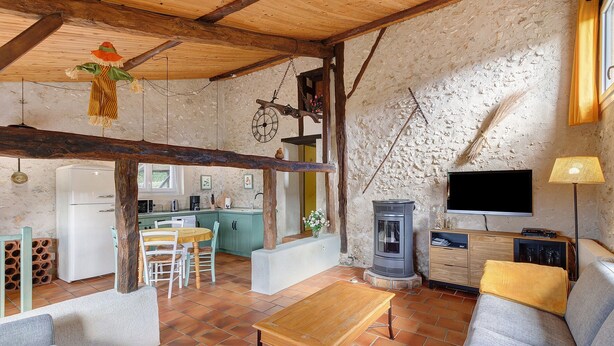 Ein rustikales Interieur mit Holztisch, Sofa und Fernseher.