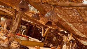 A rustic wooden counter with various fruits and vegetables, a woven basket, and a rustic interior with wooden beams and thatched roofing. - Domaine FINCA LESSYA & SPA, Elegant lodge with pool view (Mauguio)