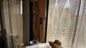 A hot tub with a straw hat on the edge, surrounded by wooden panels and a window with a textured blind. - Domaine FINCA LESSYA & SPA, Elegant lodge with pool view (Mauguio)