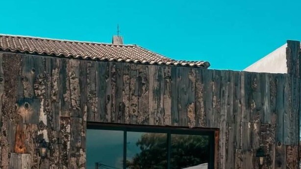 A pool with clear water, two white bean bags, and a rustic wooden building with a tiled roof. - Domaine FINCA LESSYA & SPA, Elegant lodge with pool view (Mauguio)