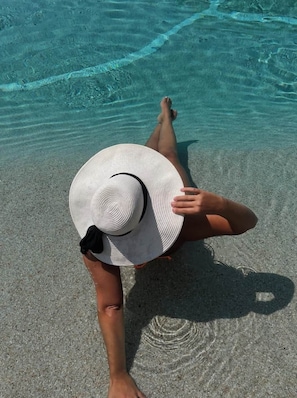 A person lying on a beach with clear water and sand. - Finca Lessya Estate, Cocon du Patio Lodge (Mauguio)