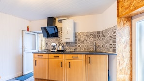 Une cuisine avec des meubles en bois, un plan de travail noir et un revêtement mural décoratif.