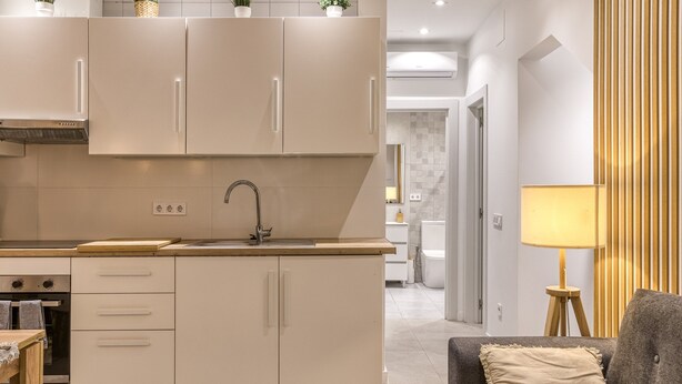 A modern kitchen with a central island, built-in appliances, and a dining area with a sofa and lamp. - Vacation Home 'Ester & David' with Wi-Fi and Air Conditioning (Palamós)