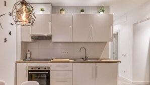 A modern kitchen with white cabinets, a built-in oven, a stainless steel sink, and a wooden countertop. - Vacation Home 'Ester & David' with Wi-Fi and Air Conditioning (Palamós)