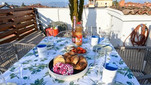 A table set outdoors with a variety of food items, a bottle, and glasses. - MGH Luxury - Sunset Lakeview House Desenzano (Desenzano del Garda)
