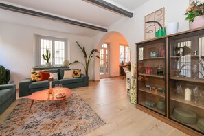 A living room with a sofa, coffee table, and a glass cabinet with decorative items. - MGH Luxury - Sunset Lakeview House Desenzano (Desenzano del Garda)