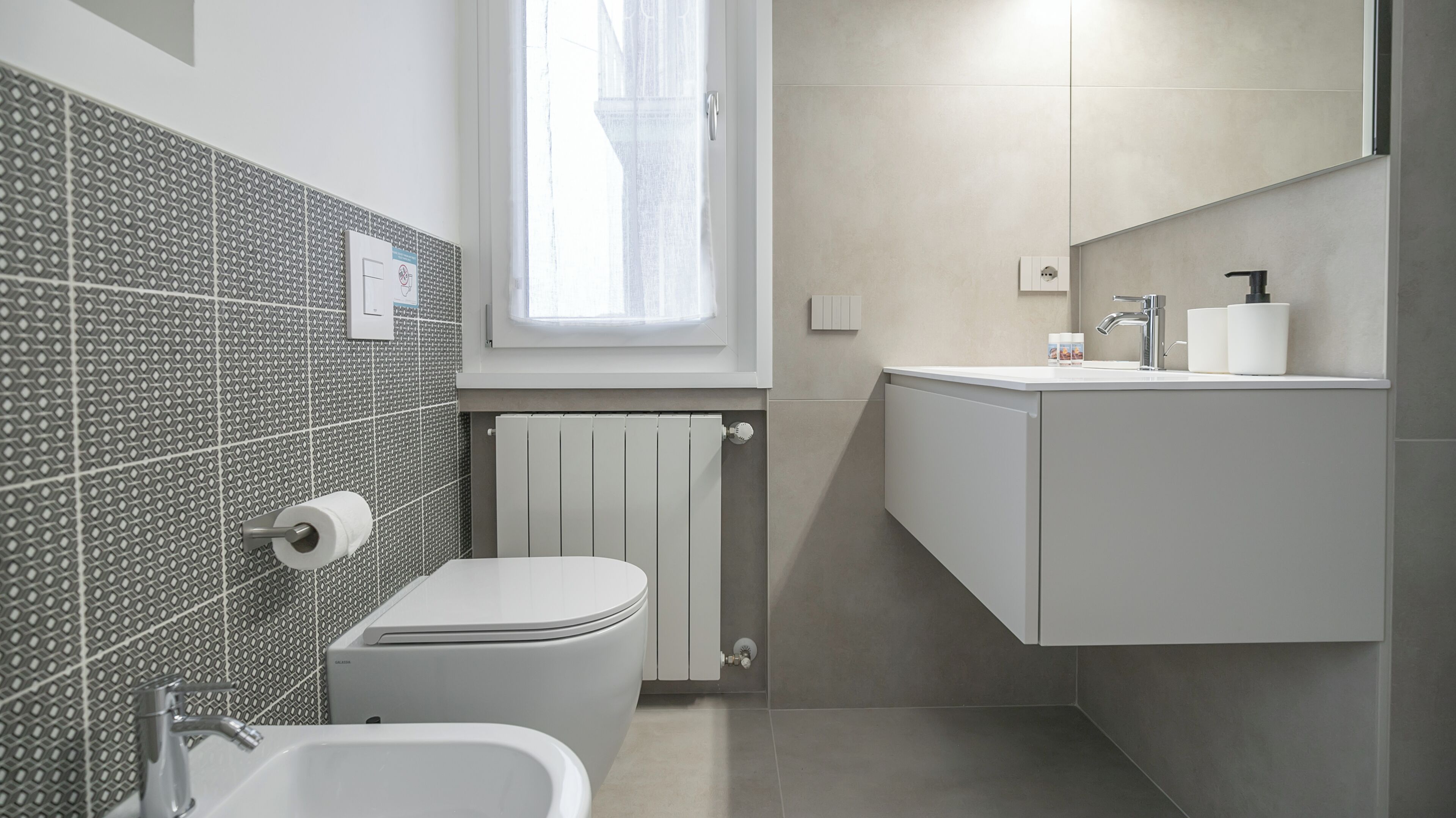 Une salle de bain moderne équipée de toilettes, d’un bidet et d  ’un lavabo.