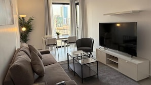 Ein modernes Wohnzimmer mit einer Couch, einem Couchtisch und einem Fernseher.