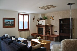 A living room with a fireplace, a sofa, a coffee table, and a bookshelf.