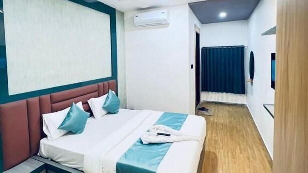 Ein modernes Hotelzimmer mit einem großen Bett, einem Deckenventilator, einer Klimaanlage und Blick auf den Flur.