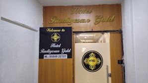Ein Hotel Eingang mit einem Schild, auf dem 'Hotel Radiyesan Gold' steht, und einem Willkommensschild mit dem Hotel-Logo.