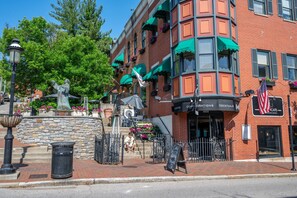 A brick building with a cafe, outdoor seating, and a statue. - StayPavilionMtAdams | Cincinnati (Cincinnati)