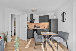 Eine moderne Küche mit dunklen Schränken, einer Holzarbeitsplatte und einem eingebauten Backofen.