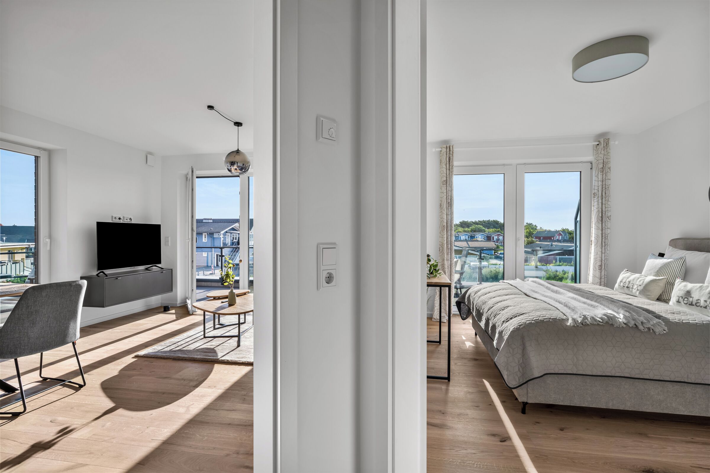 Une chambre moderne avec un grand lit, une télévision et une vue sur la ville.