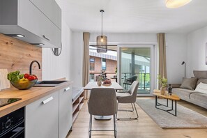 Eine moderne Küche mit einer Holzausziehtafel, einer Obstschale und einem Essbereich mit Tisch und Stühlen.