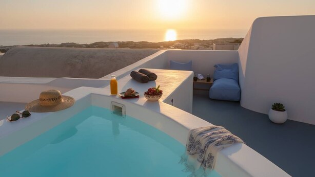 Una terraza en la azotea con piscina, un sillón de descanso y una mesa lista para el desayuno.