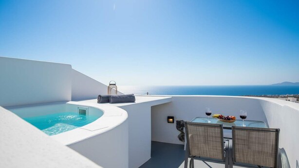 En tagterrasse med swimmingpool, et bord med stole og havudsigt.
