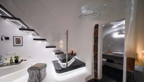 Een moderne badkamer met een strak design, met een marmeren aanrechtblad, een vrijstaand wastafelmeubel en een douchecabine van glas.
